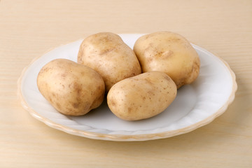Fresh potatoes on a white plate