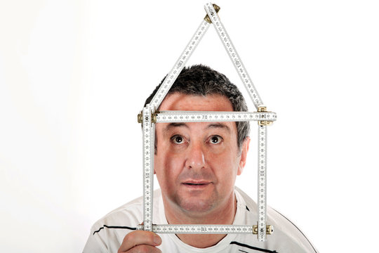 Mann mit Zollstock zum Haus geformt