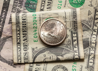 Dollar and half coin on top of single bank note