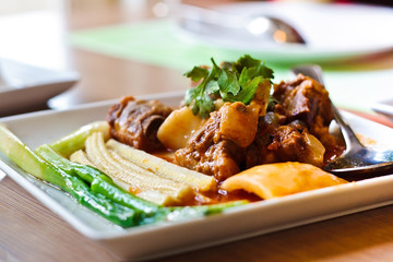 Pork rib roast with a sweet sauce on a white plate.