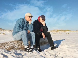 Two Bored Retired Men Sitting Together at the Beach