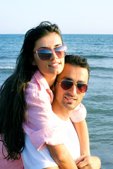 Happy couple at the beach in a playful mood
