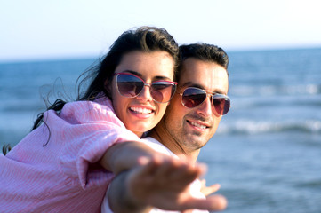 Fototapeta premium Happy couple at the beach in a playful mood