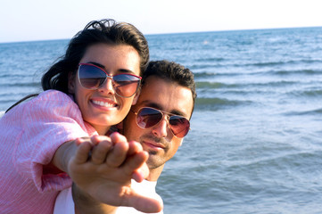 Happy couple at the beach in a playful mood