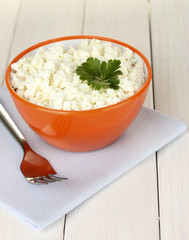 cottage cheese with parsley in orange bowl and fork