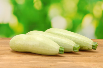 squash on wooden table on green background close-up