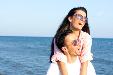 Happy couple at the beach in a playful mood