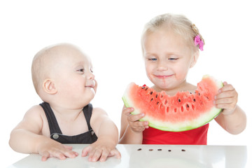 Little girl and boy eating a watermelon