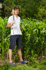 Young farmer near a corn field