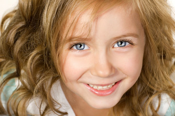 close-up portrait big smiling little girl wiht blue eyes