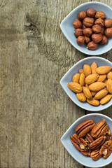 Almonds, hazelnuts and pecans on  wooden background