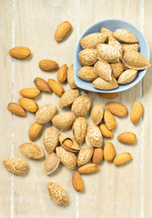Almonds in shell and unshelled on a wooden table