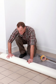 Man Unrolling Carpet Roll