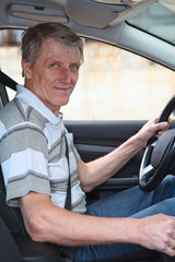 Mature experienced driver male sitting inside of his car