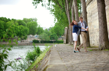 Fototapeta na wymiar Happy couple is dancing on the Seine embankment in Paris