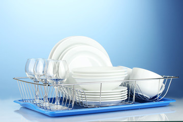 clean dishes on stand on blue background