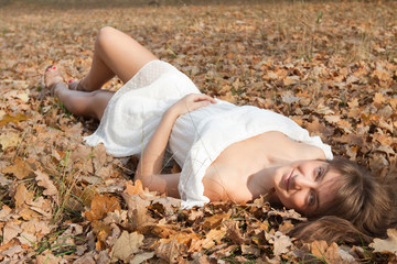 Fototapeta premium girl lies in oak leaves
