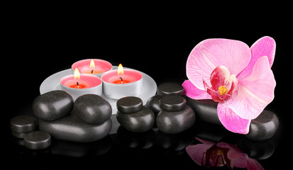 Obraz na płótnie Canvas Spa stones with orchid flower and candles isolated on black