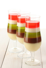 fruit jelly with berries in glasses on wooden table