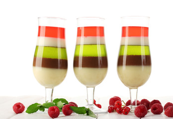 fruit jelly in glasses, berries and mint on wooden table