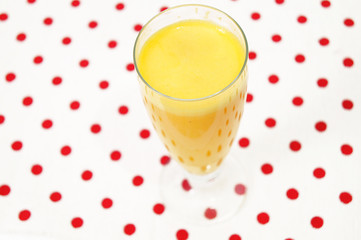 Orange juice isolated on homey red dotted background