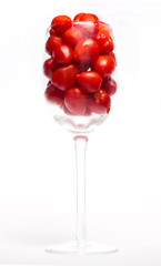 Red tomatos in wine glass white background