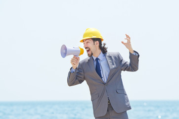 Man wearing helmet speaks with megaphone