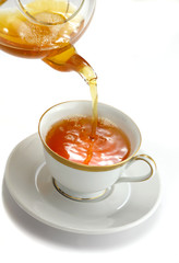 Pouring tea from the tea pot to the cup
