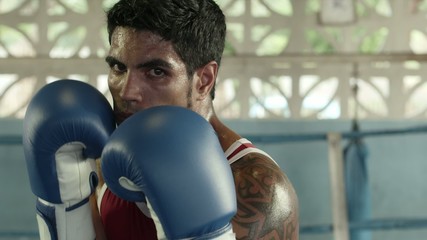 Portrait of caucasian boxer on ring looking at camera