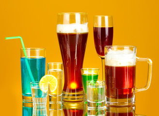 a variety of alcoholic drinks on yellow background