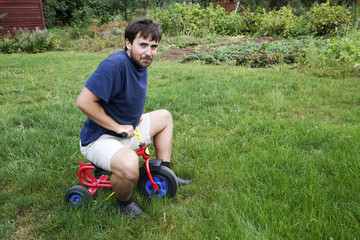 Adult man on a small tricycle