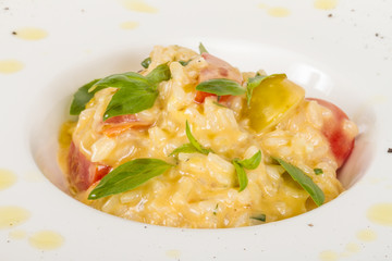 photo of delicious risotto dish with herbs and tomato on white b