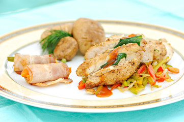 meal with prepared chicken meat, bacon rolls and vegetables