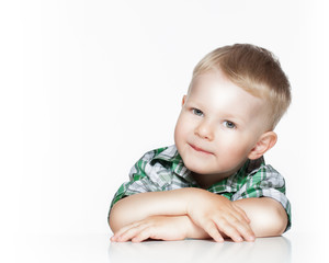 Portrait of a cute little boy smiling while sitting at table,