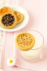 Cookie on a glass of milk on pink napkin