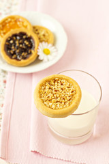 Cookie on a glass of milk with more cookies in background