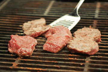 A beefsteak being cooked on a barbecue