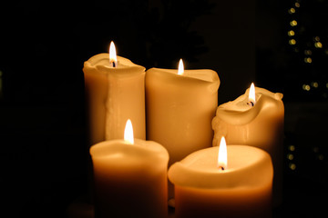 Fototapeta na wymiar Five candles burning in the darkness
