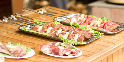 Appetizing weal kebab on skewers with tomatoes, pepper, greens