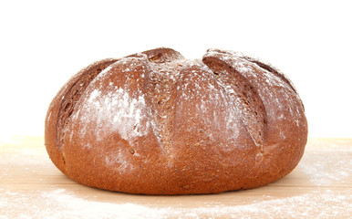 Homemade whole bread on wooden cutting board close-up