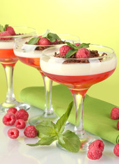 fruit jelly with berries in glasses on green background