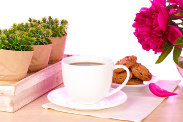 cup of coffee, cookies and flowers on table in cafe