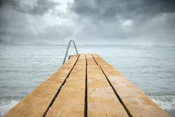 Fototapeten Wooden pier with sea in a gloomy day © vali_111