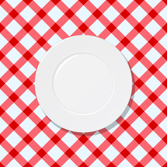 White plate on red and white checked tablecloth