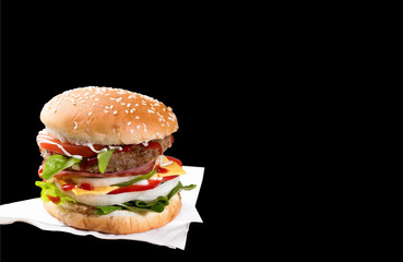 Cheeseburger with tomatoes and lettuce on black background
