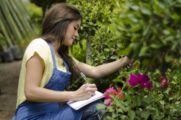 Beautiful female gardener working on inventory