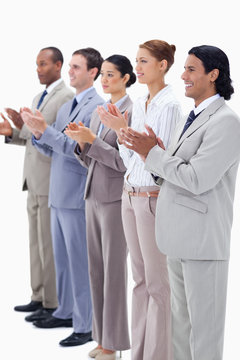 People dressed in suits smiling and applauding