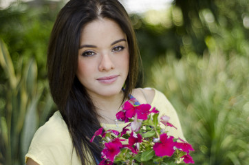 Cute gardener taking care of some flowers in a garden