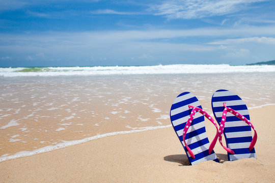 Colorful flipflop pair on sea beach