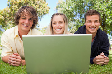 Close-up of three happy students in a park